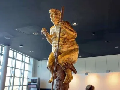 Una estatua dorada de Trump desnudo con un palo de golf sorprende al Parlamento Europeo